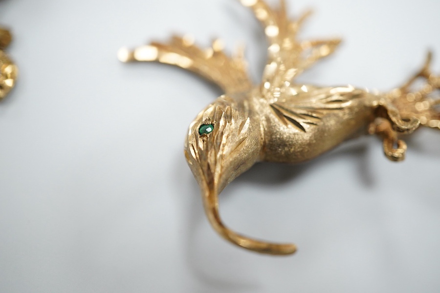 Two 9ct gold brooches, one designed as a collared leopard, its eyes set with rubies, length 5.2cm; the other designed as a hummingbird in flight, its eye set with an emerald, length 4.9cm, each in textured 9ct gold, Brit